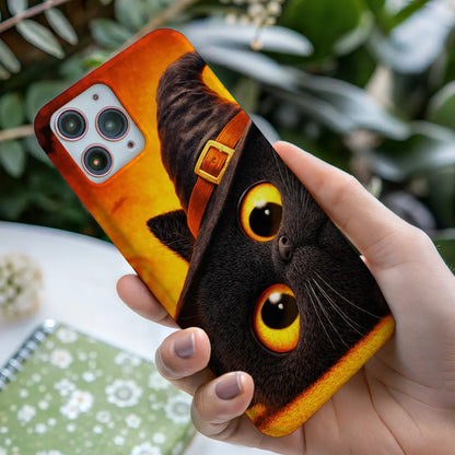 In-hand view of Witch Kitty case highlighting the amber eyes and fur texture.