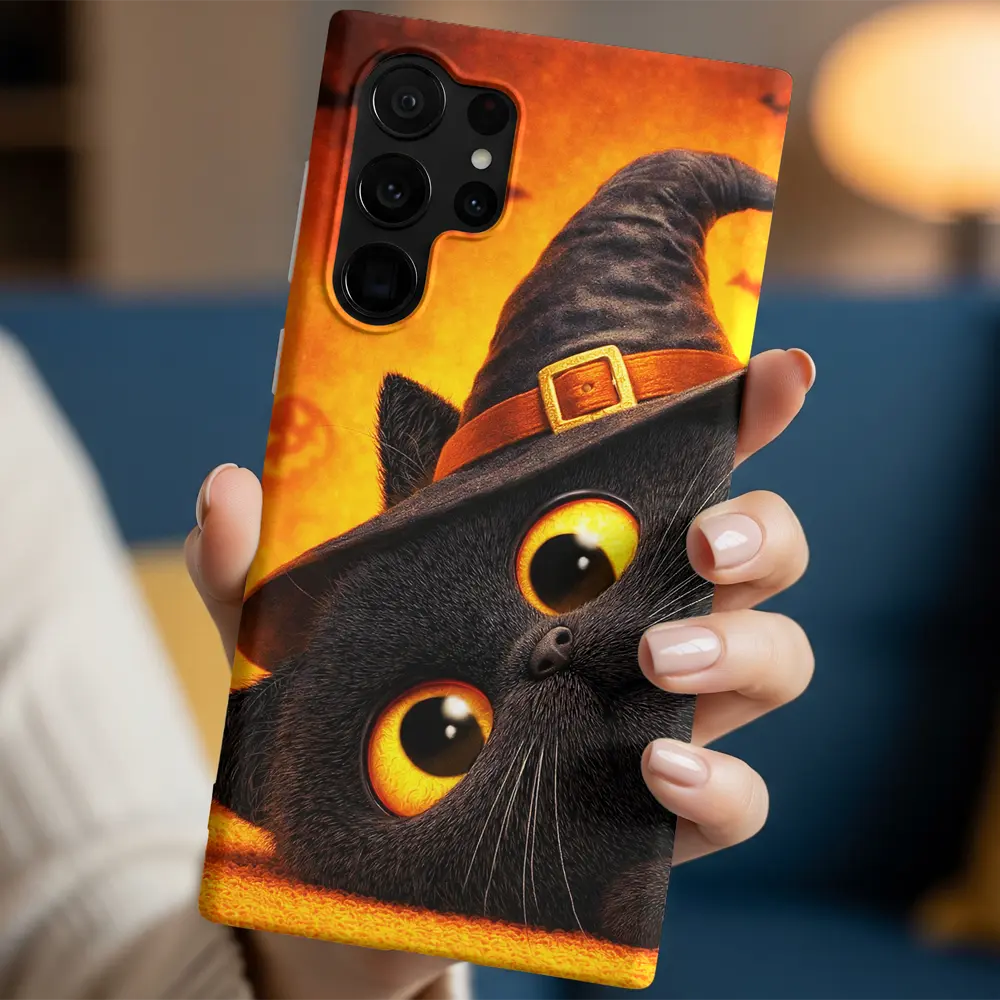 In-hand view of Witch Kitty case highlighting the amber eyes and fur texture.
